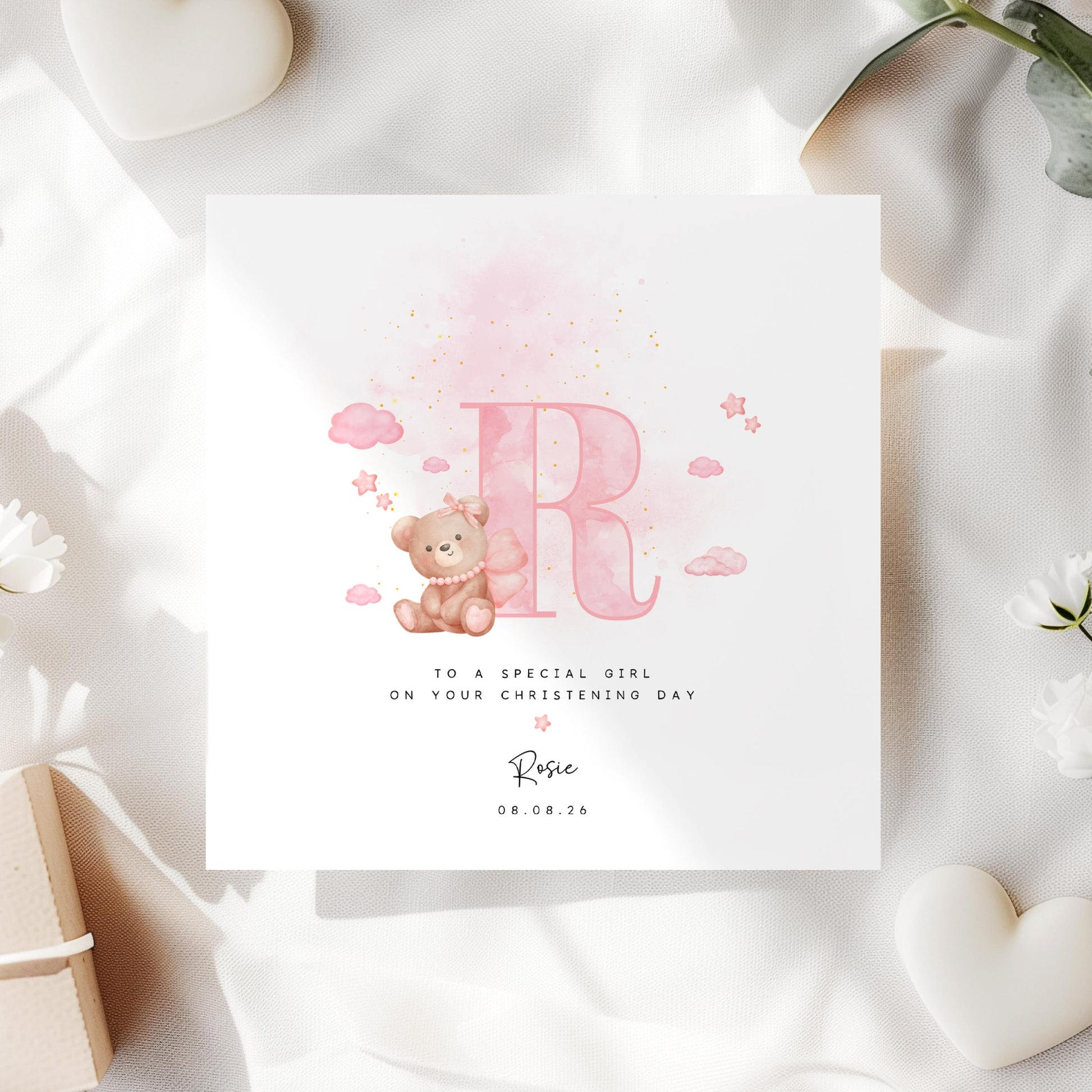 Personalised baptism card for baby girl with pink watercolour letter, teddy bear on cloud, and custom name and date. Perfect for christening or naming day keepsakes.
