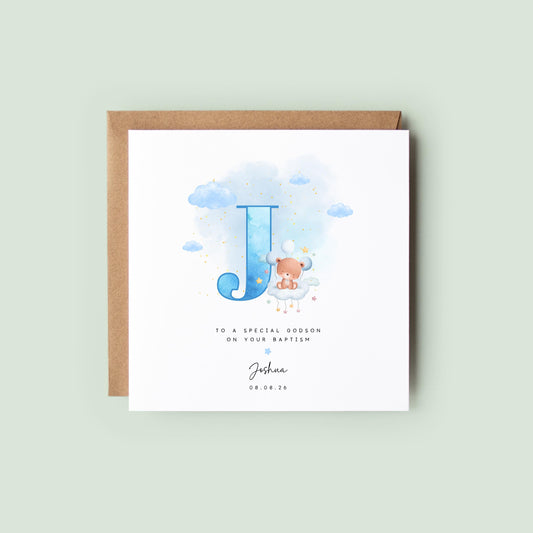 Personalised baptism card for baby boy with blue watercolour letter, teddy bear on cloud, and custom name and date. Ideal for christenings or naming days.