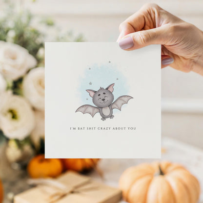 Cute watercolour Halloween greeting card featuring an adorable smiling bat with the humorous message "I'm Bat Shit Crazy About You."