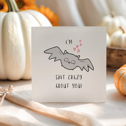 Funny Halloween greeting card featuring a cute grey bat with pink hearts and the humorous message "I'm Bat Shit Crazy About You."