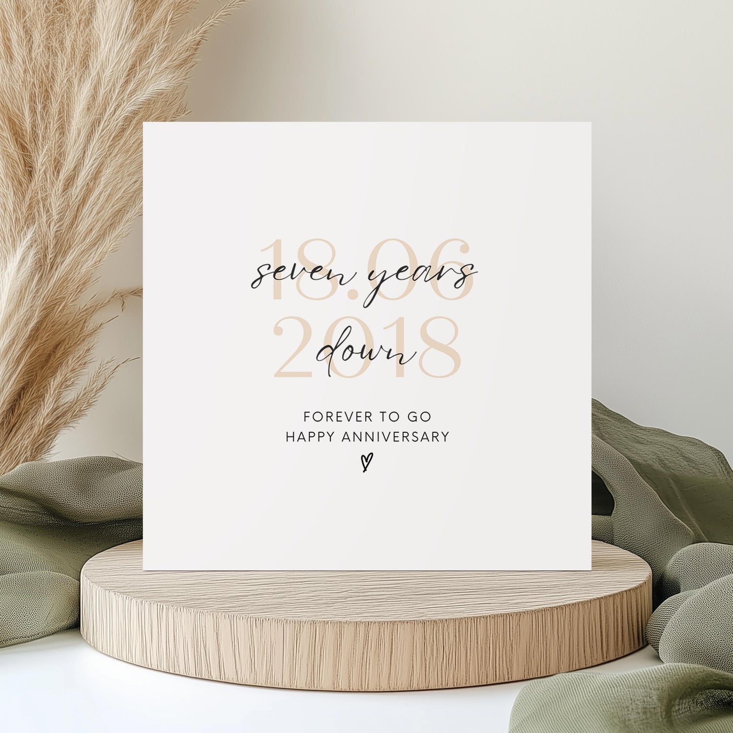 Personalised seven-year anniversary card featuring soft beige date, script text reading “Seven Years Down”, and a small heart detail.