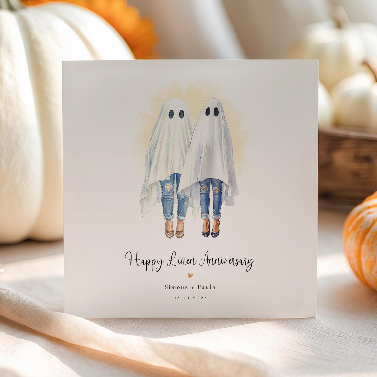 Personalised lesbian linen anniversary card featuring two women dressed as ghosts in a cute Halloween watercolour style, with names and wedding date.