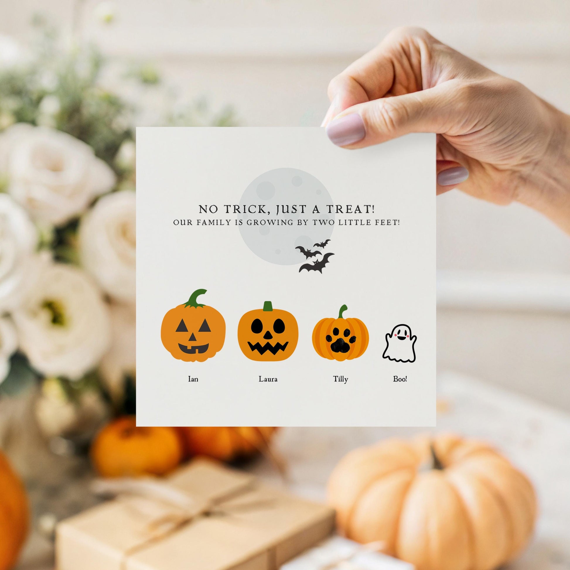 Personalised Halloween pregnancy announcement card with pumpkins and a ghost representing family members, and the phrase “Our family is growing by two little feet!”