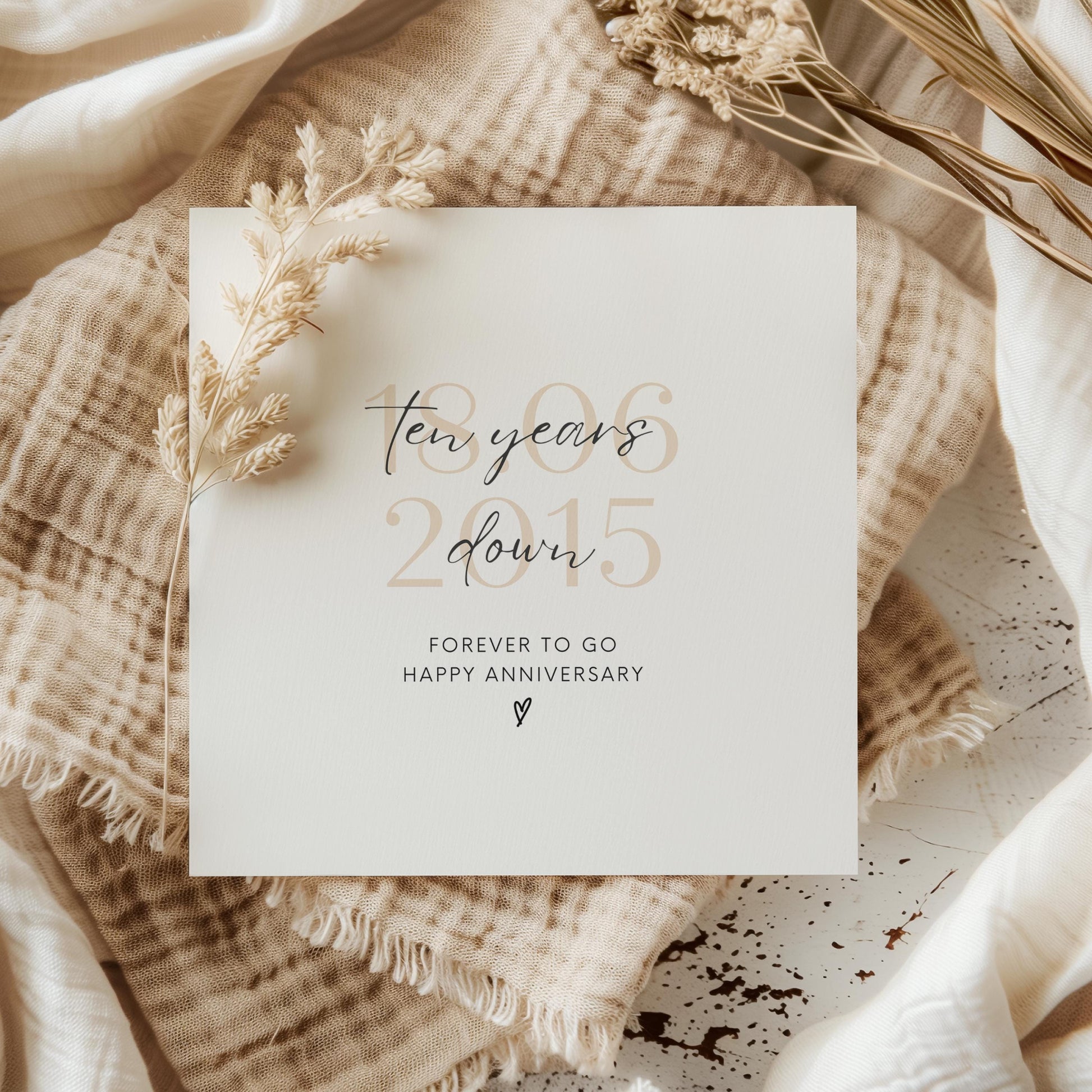 Personalised ten-year anniversary card featuring soft beige date, script text reading “Ten Years Down”, and a small heart detail.