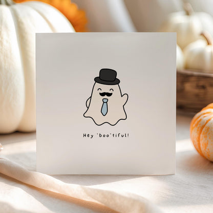 Cute Halloween greeting card featuring a smiling ghost wearing a top hat, moustache and blue tie with the pun "Hey Boo'tiful!"
