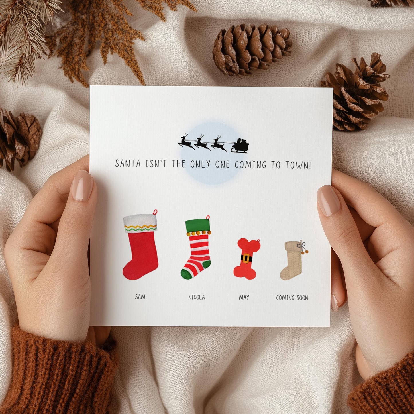 Personalised Christmas pregnancy announcement card with festive stockings and “Santa isn’t the only one coming to town” text, ideal for sharing baby news.