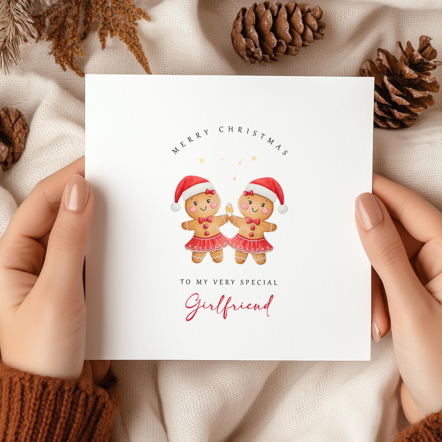 Lesbian Christmas card featuring two adorable gingerbread girls wearing Santa hats and festive skirts.