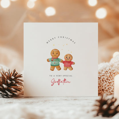 Christmas card for godfather from godson, featuring two gingerbread boys in festive jumpers on a cosy Christmas scene with warm lighting.