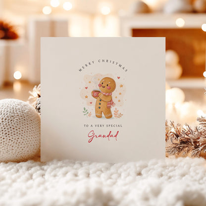 Cute Grandad Christmas card featuring a smiling gingerbread character wearing a scarf and holding a warm festive drink.