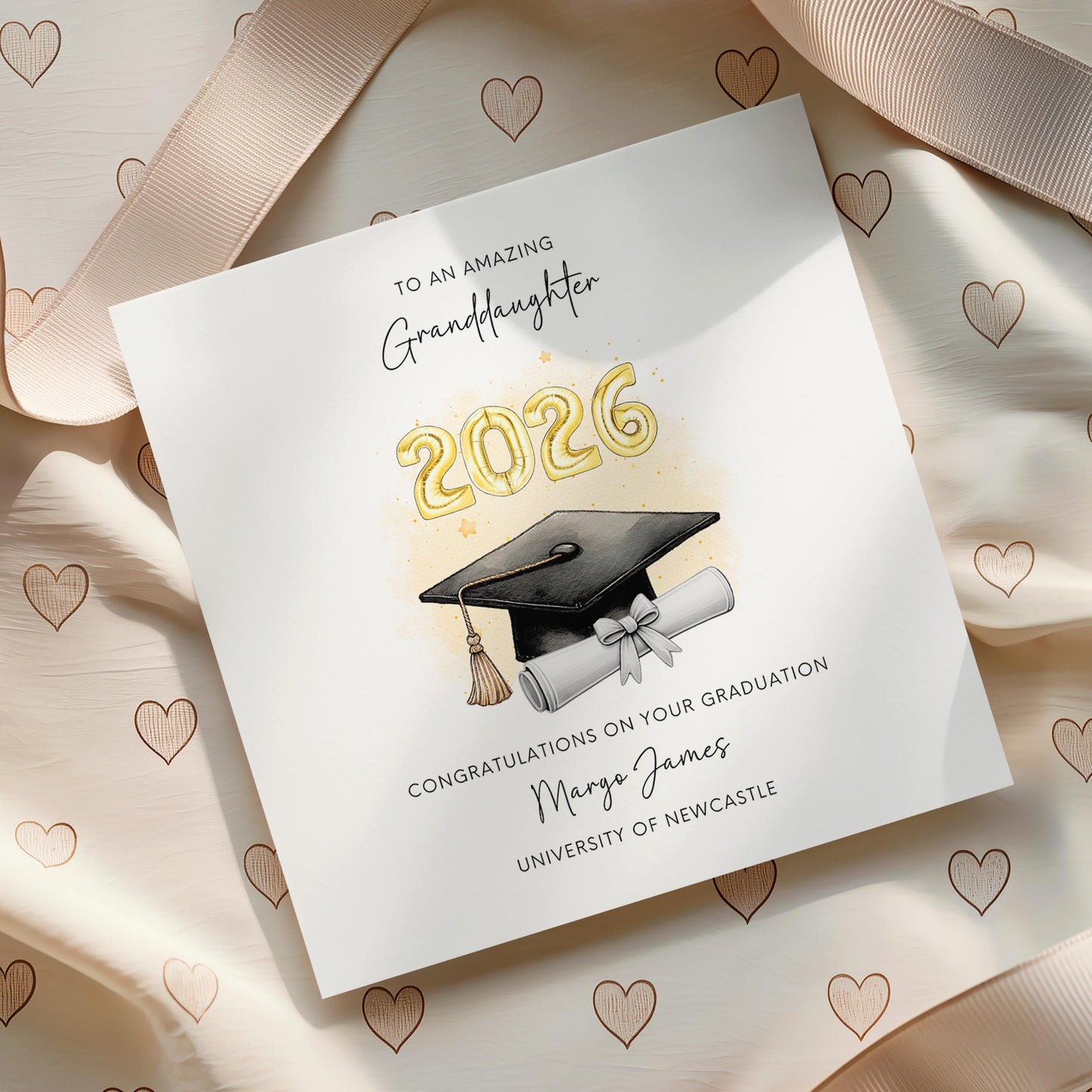 Personalised granddaughter graduation card featuring gold 2026 balloons, graduation cap and diploma scroll. Custom university graduation card with granddaughter title, graduate name, university details and congratulations message.