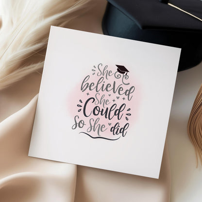 Graduation card for her featuring the quote “She Believed She Could So She Did” with a graduation cap and soft pink background. Inspirational congratulations card for female university graduates, college graduates and academic achievements.