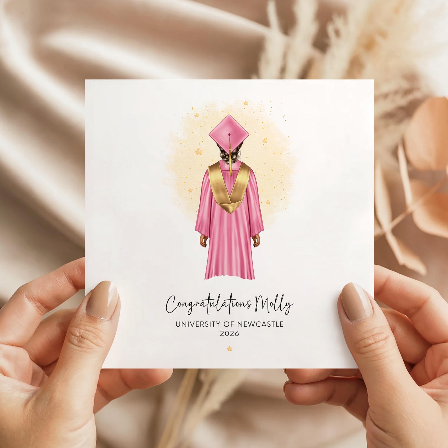 Personalised female graduation card featuring a graduate wearing a pink cap and gown with custom hair, skin tone, university name and graduation year. Personalised congratulations card for Class of 2026 graduates.