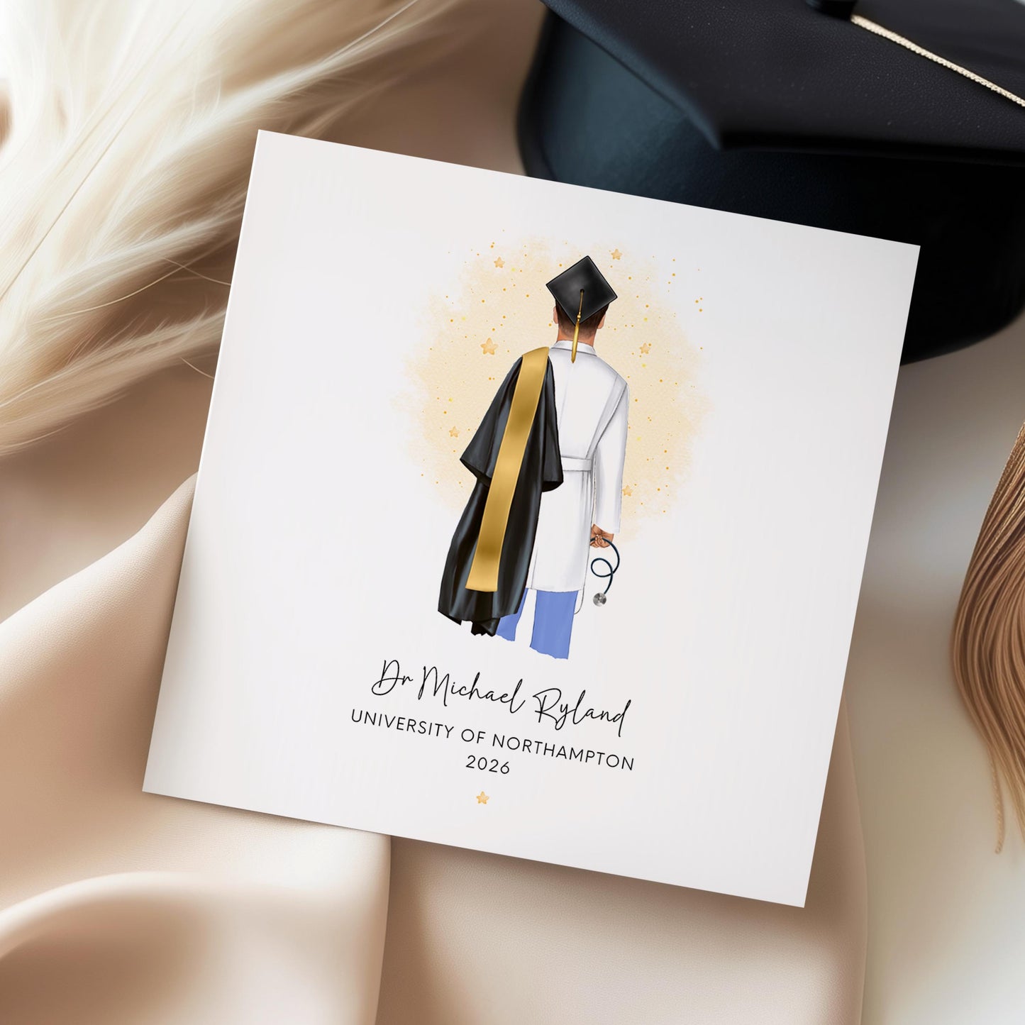 Personalised doctor graduation card featuring a medical graduate in cap and gown with scrubs and stethoscope, customised with name, university and graduation year, displayed with personalisation options.