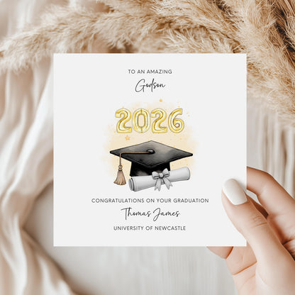 Personalised godson graduation card featuring gold 2026 balloons, graduation cap and diploma scroll. Custom university graduation card with godson title, graduate name, university details and congratulations message.