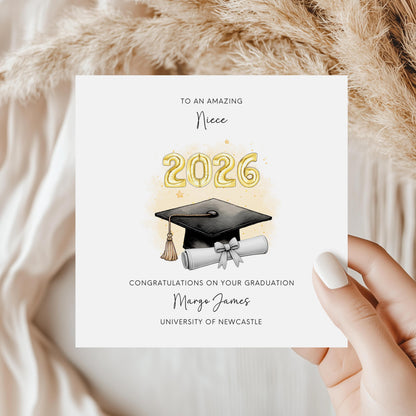 Personalised niece graduation card featuring gold 2026 balloons, graduation cap and diploma scroll. Custom university graduation card with niece title, graduate name, university details and congratulations message.