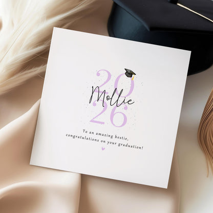 Personalised bestie graduation card featuring custom name, graduation year 2026, graduation cap illustration and congratulations message. Custom graduation keepsake card for celebrating a best friend’s university or college achievement.