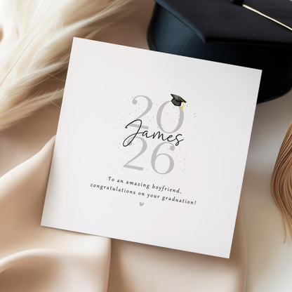 Personalised graduation card for boyfriend featuring custom name, Class of 2026 design, graduation cap, personalised message and heart colour on a modern minimalist keepsake card.