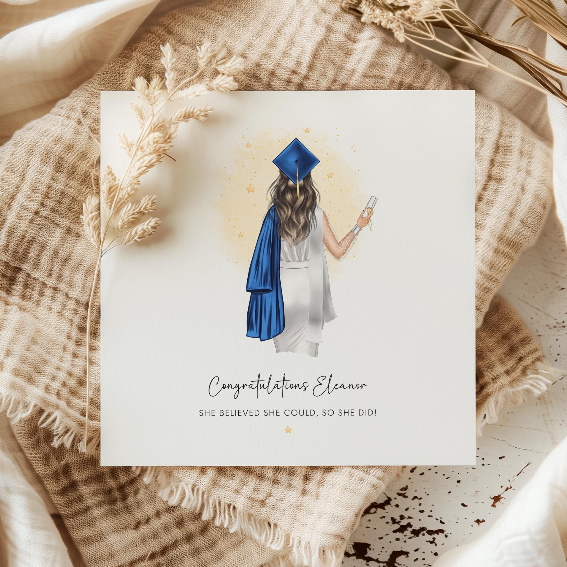 Personalised graduation card featuring a female graduate wearing a blue cap and gown, customised with name and the message “She Believed She Could, So She Did”.