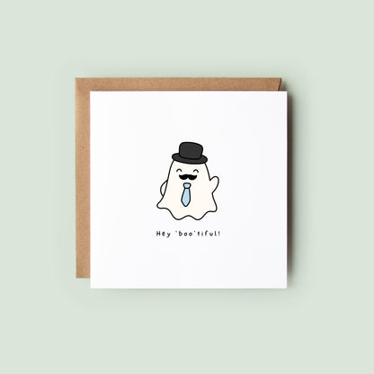 Cute Halloween greeting card featuring a smiling ghost wearing a top hat, moustache and blue tie with the pun "Hey Boo'tiful!"