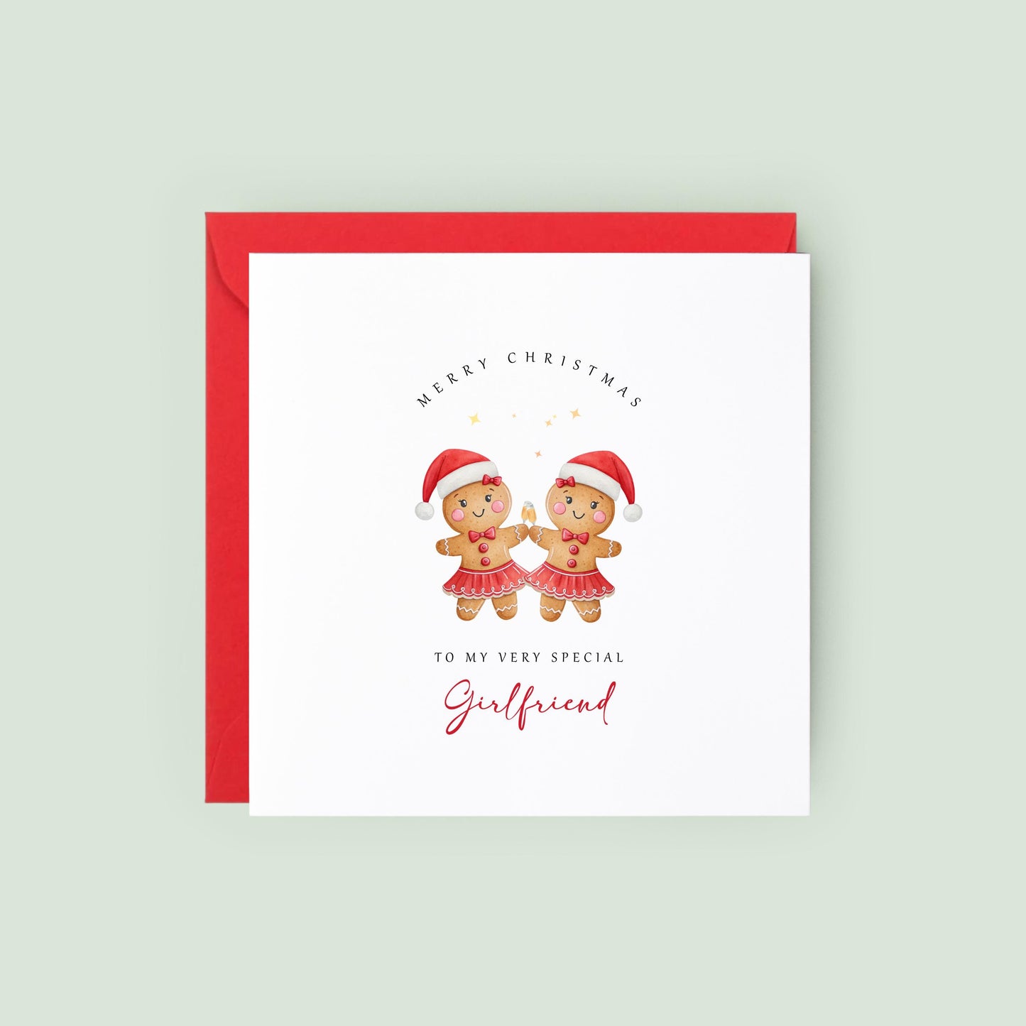 Lesbian Christmas card featuring two adorable gingerbread girls wearing Santa hats and festive skirts.