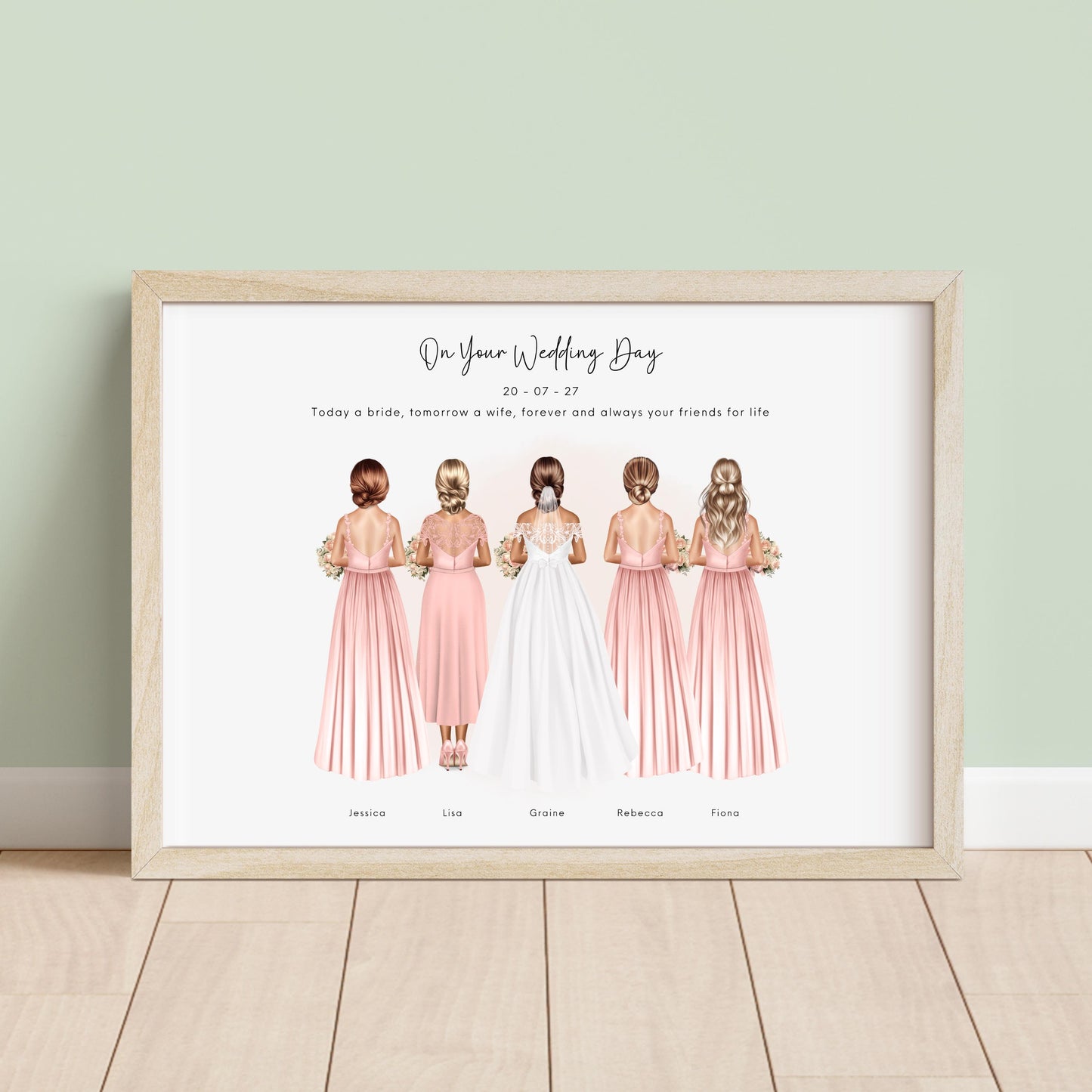 Framed personalised bridesmaid print showing bride and four bridesmaids illustrated from behind in blush dresses with bouquets, plus wedding date and names underneath, displayed in a light wood frame against a neutral background.
