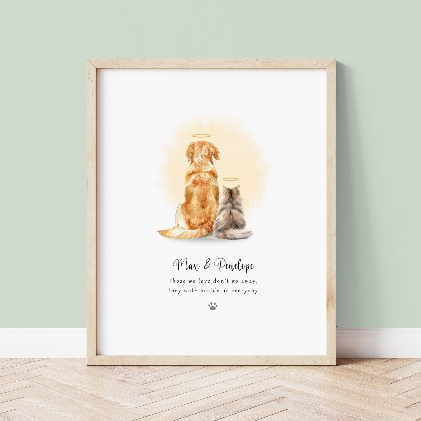 Personalised Rainbow Bridge pet memorial print for two pets sitting side by side with soft watercolour halos and the quote “Those we love don’t go away, they walk beside us every day”, customised with the pets’ names and wording, shown framed on a neutral wall.
