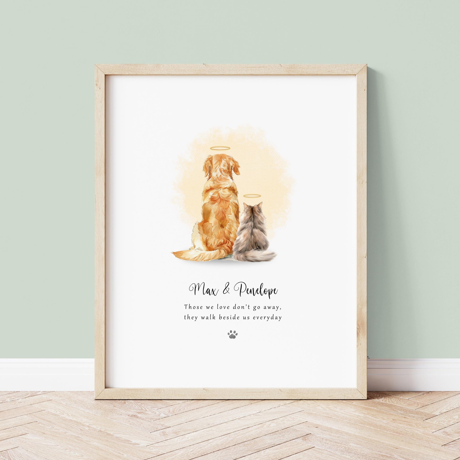 Personalised Rainbow Bridge pet memorial print for two pets sitting side by side with soft watercolour halos and the quote “Those we love don’t go away, they walk beside us every day”, customised with the pets’ names and wording, shown framed on a neutral wall.