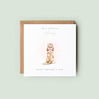 Personalised pet Mother’s Day card from the dog or cat with a watercolour pup sitting in a pastel flower crown and pink bow, with soft heart background and “To a special Mummy – Happy Mother’s Day”, shown as a square 148x148mm (6x6) card with Kraft envelope behind.